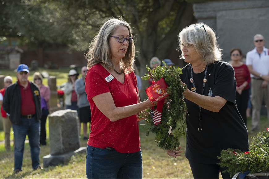 Judiann Rakes and Dee Clark lay a Veterans wreath during last year's Wreath Across America service. File photo by Michele Meyers