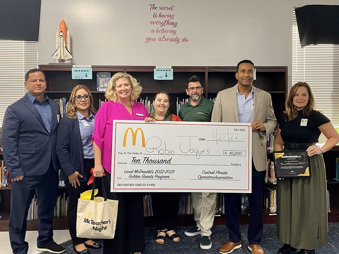 Robin Jaques, third from left, accepts the award with (from left) Filberto Rosa Cruz, Joselyn Cruz, Julissa Williams, Bunnell Elementary School Principal Marcus Sanfilippo, Joe Cox and Jodi Cox. Courtesy photo