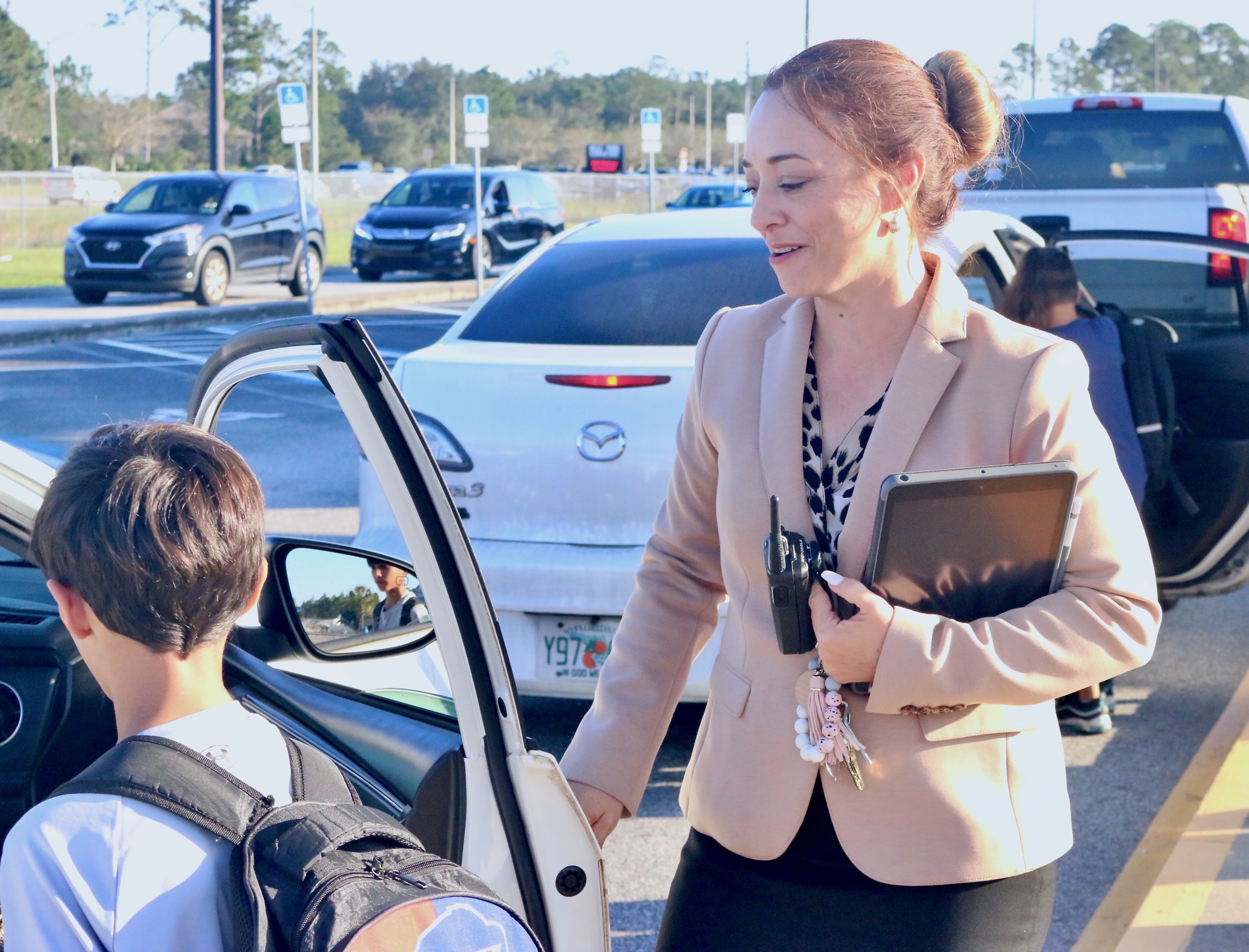 Principal Jessica DeFord takes the time to help her students into their cars, saying goodbye with a smile. Photo by Sierra Williams