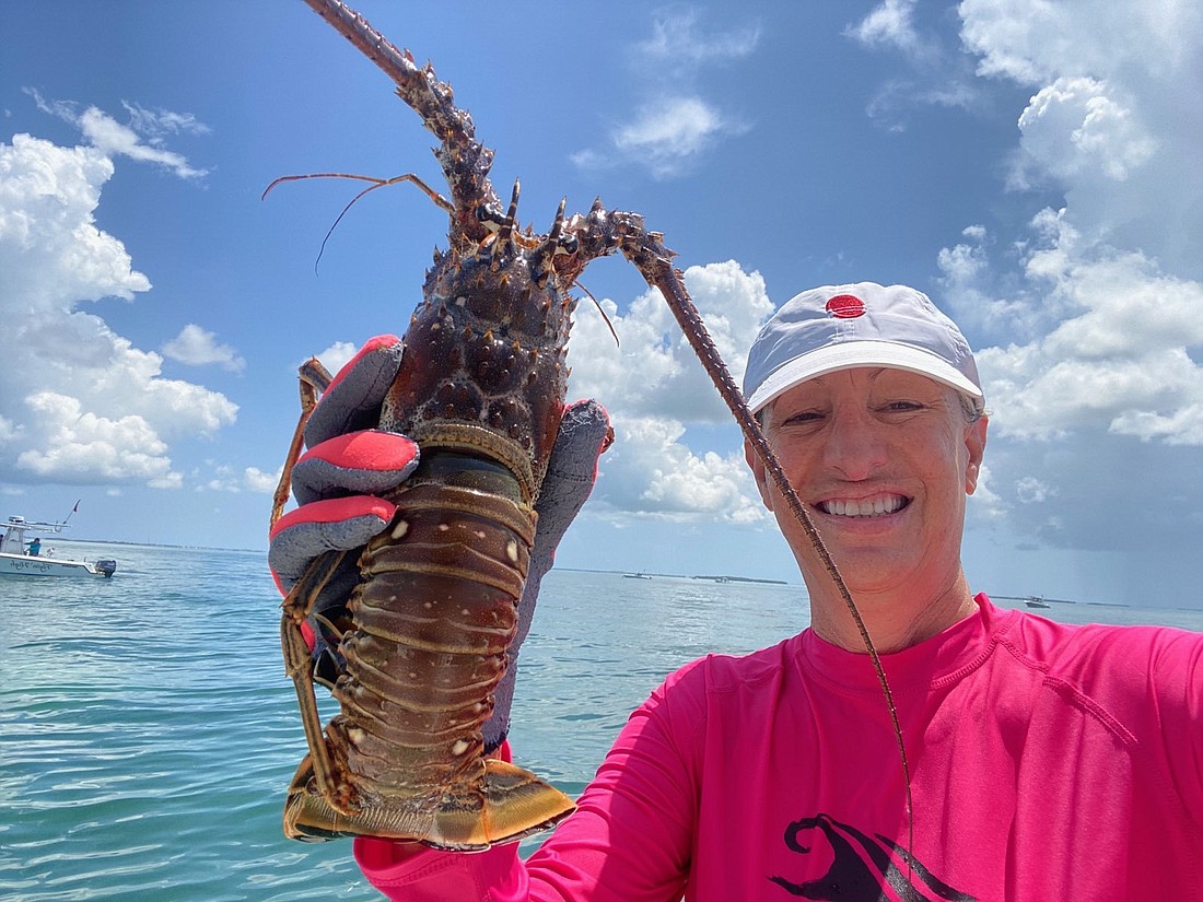 Gerri Moll shows off a lobster she caught.