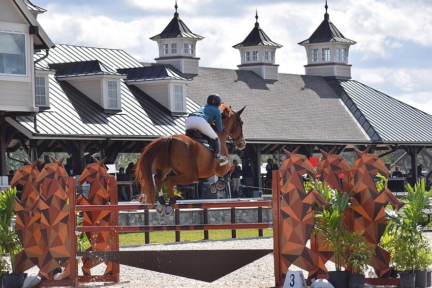 Haley Gassel, aboard Iliano Van D'Abelendreef, goes high over a jump in front of the VIP Pavilion at TerraNova.