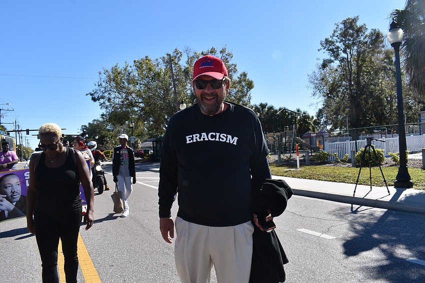 Lou Grossman wears his eracism shirt as he marches on Dr. Martin Luther King Jr Way.