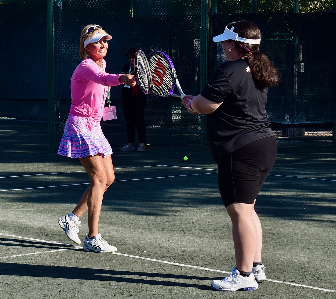 Volunteer Brenda Terihay taps rackets with Bryanna Schmidt after a successful point in a 2022 session of Tennis for Fun on Longboat Key.