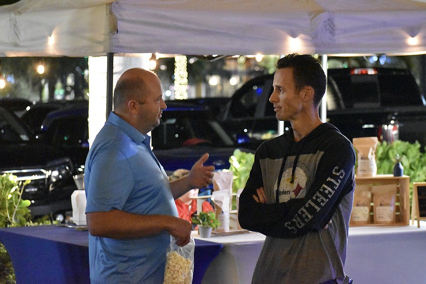 Waterside's Eugene Koshel and Sarasota's Dan Rutkowski converse during the Night Market on The Green at UTC.