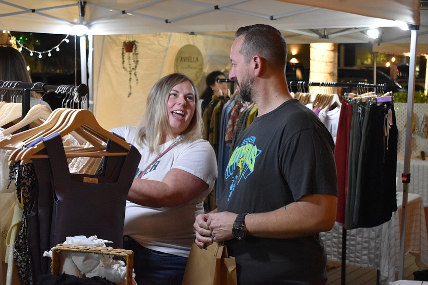The Meadows' Sarah Schoeck and Ryan Allen check out the items at Rooted and Free Co. during the Night Market.