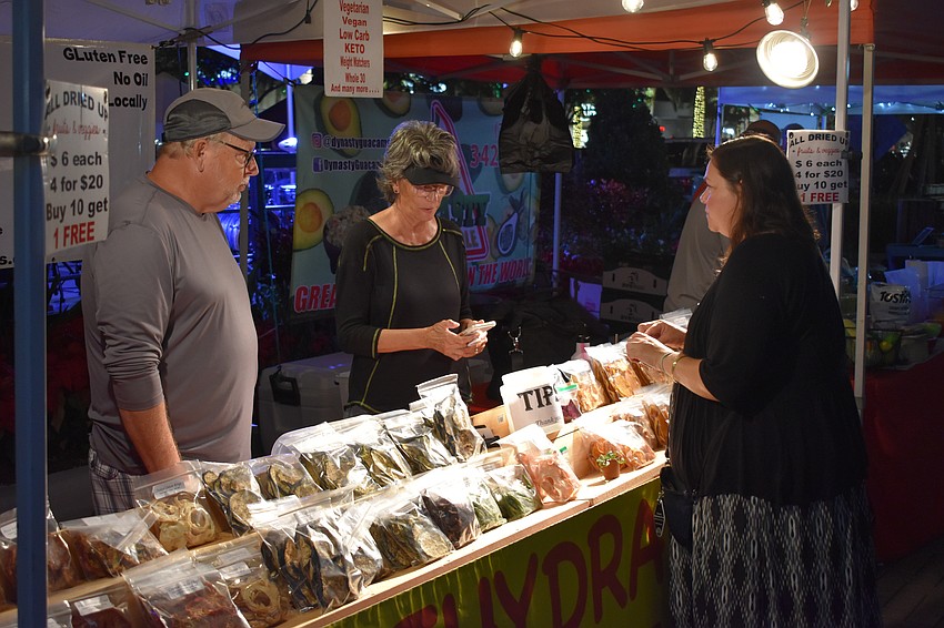 Parrish's Bill and Karen Markham of Dehydrated Fruit and Veggie Co. sell an item to Sarasota's Stephanie Tolland.