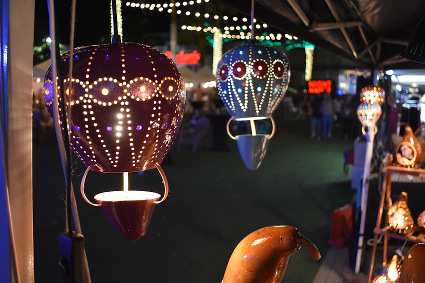 Gourds by Glowing Gourds hang in a stand at the market.
