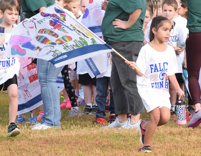 Freedom Elementary School first grader Melanie Johnson takes off holding her class' flag.