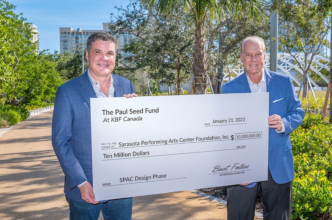 Paul Seed (left) presents the literal big check in the amount of $10 million to SPAC Foundation Board Chairman Jim Travers.