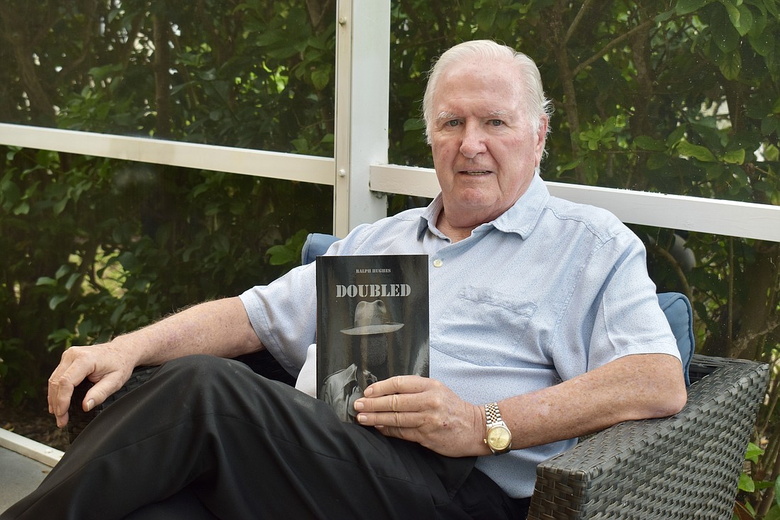 Ralph Hughes holds the first of two spy novels he wrote based on his time with the CIA.