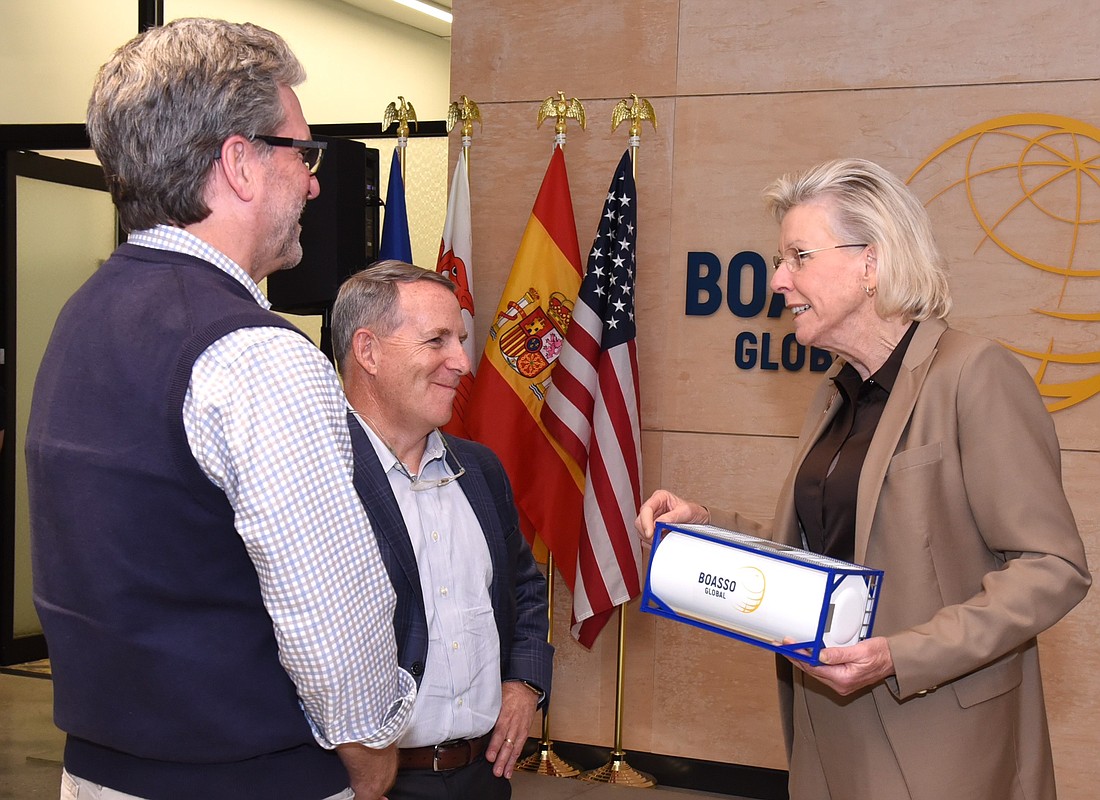 Tampa Mayor Jane Castor receives a model of an ISO tank from Boasso Global CEO Joe Troy, while Kyle Parks of B2 Communications looks on.