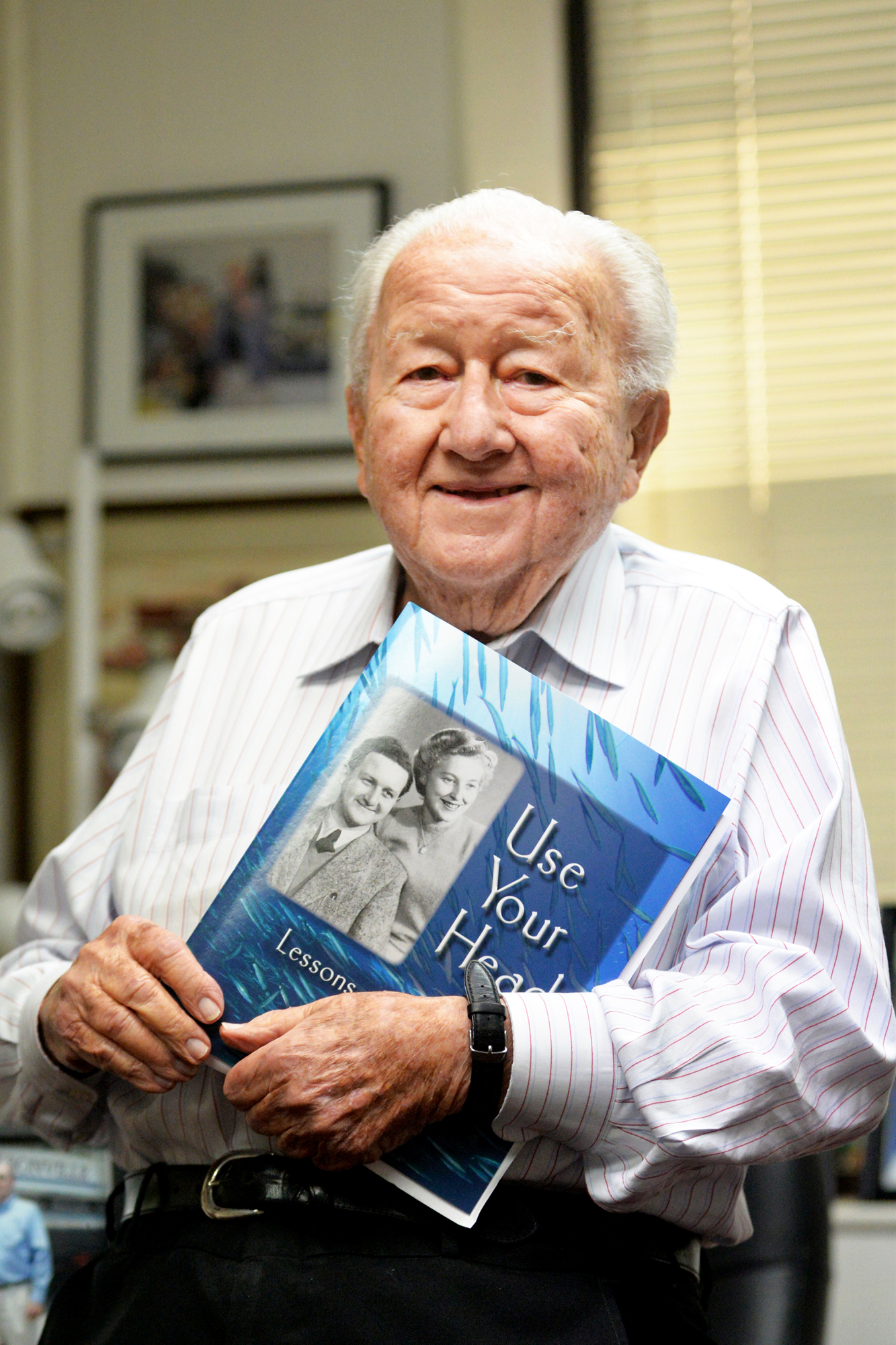 Harry Frisch holds his 2018 biography, “Use Your Head: Lessons of a Lifetime.”
