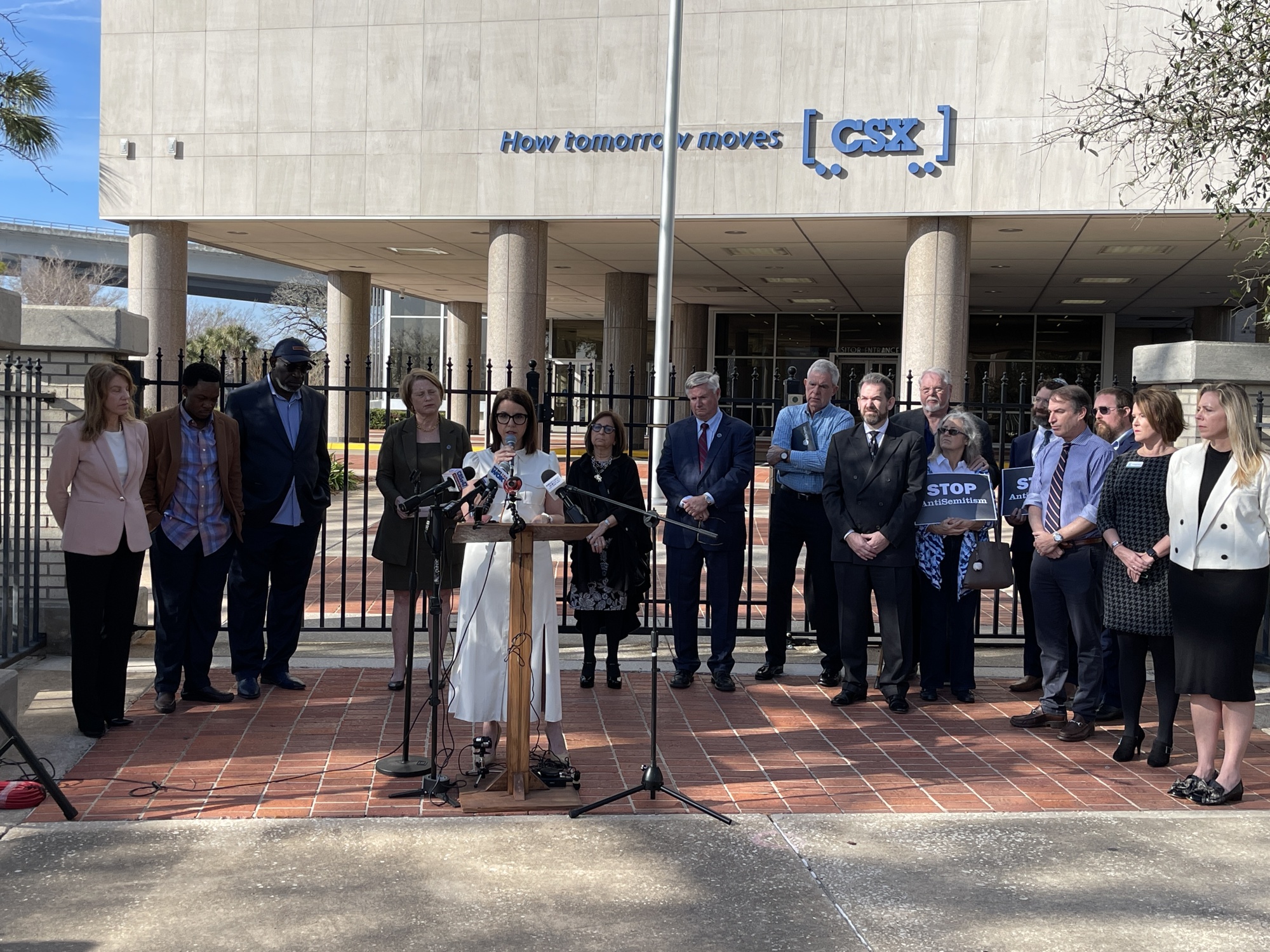 Councilmember LeAnna Cumber speaks at a news conference Jan. 19 while officials and faith leaders watch.