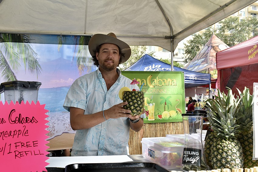 Jordan Overwater prepares a pina colada in a pineapple.