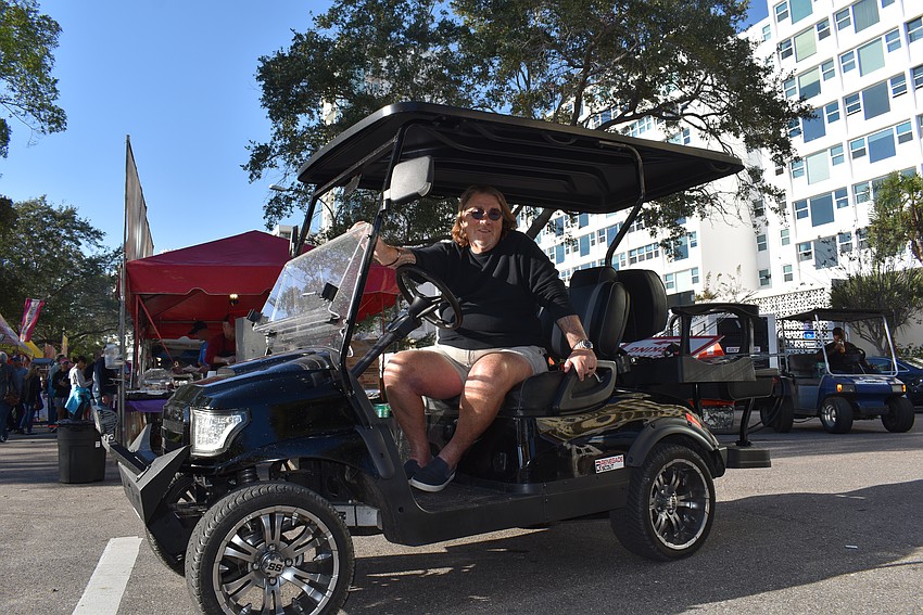 Event Organizer Bill Kinney rides in his golf cart at the 7th Annual Sarasota Seafood and Music Festival.