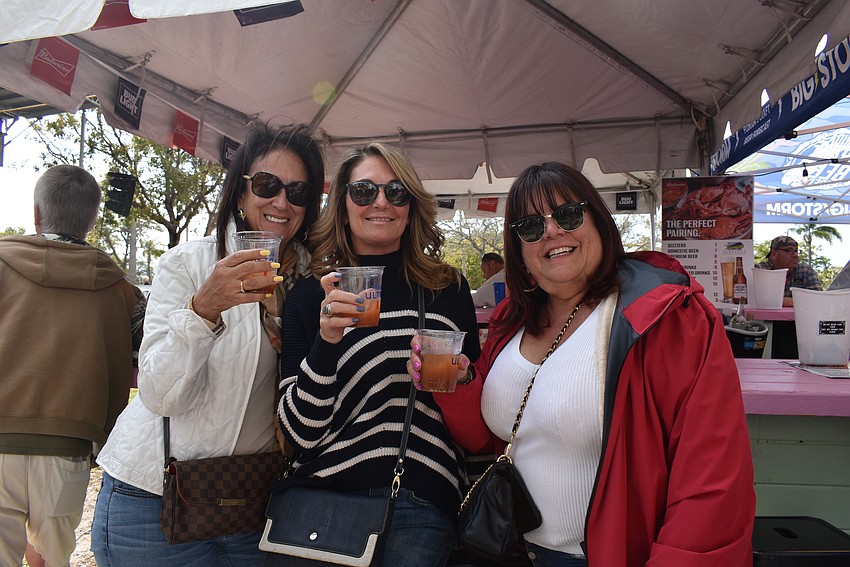 Barbi Igneri, Valerie Marchand and Tom Frank enjoy their drinks as they listen to the live musical performances.