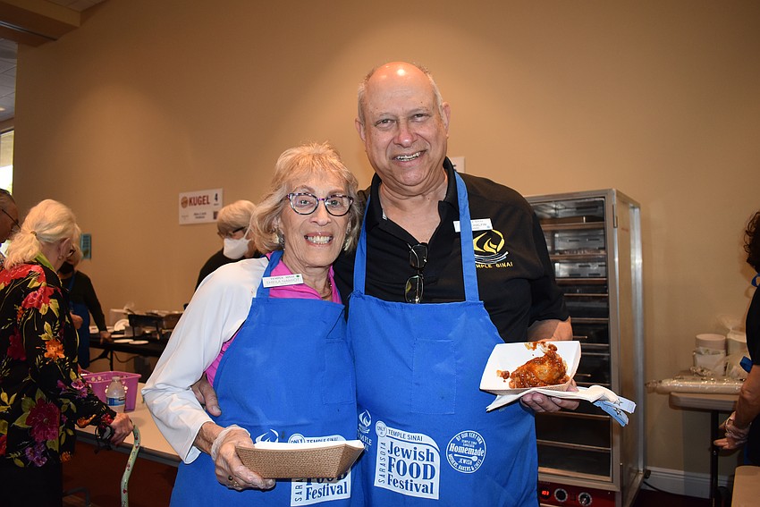 Sheila Namiot and Temple Sinoi President Alan Chalfin enjoy some traditional Jewish food.