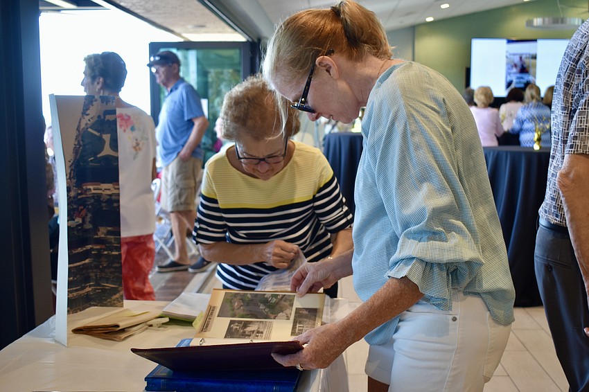 Betsy Dattalo and Janet Knight look at old photo albums.