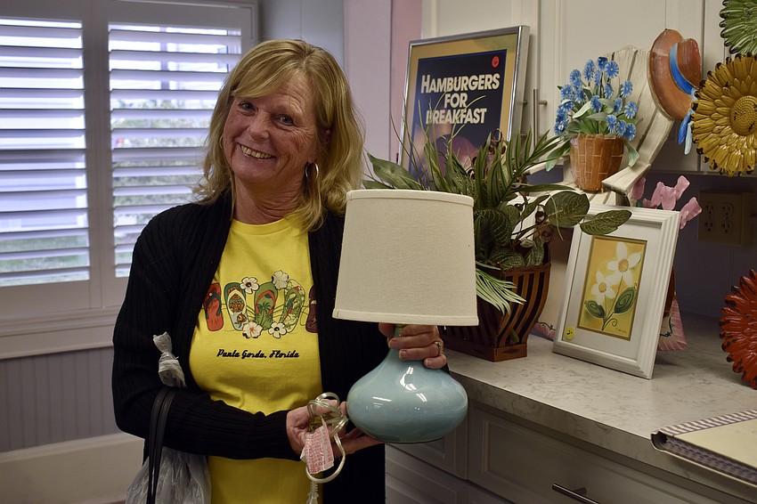 Paula Bender holds a lamp for a friend who's not finished shopping.