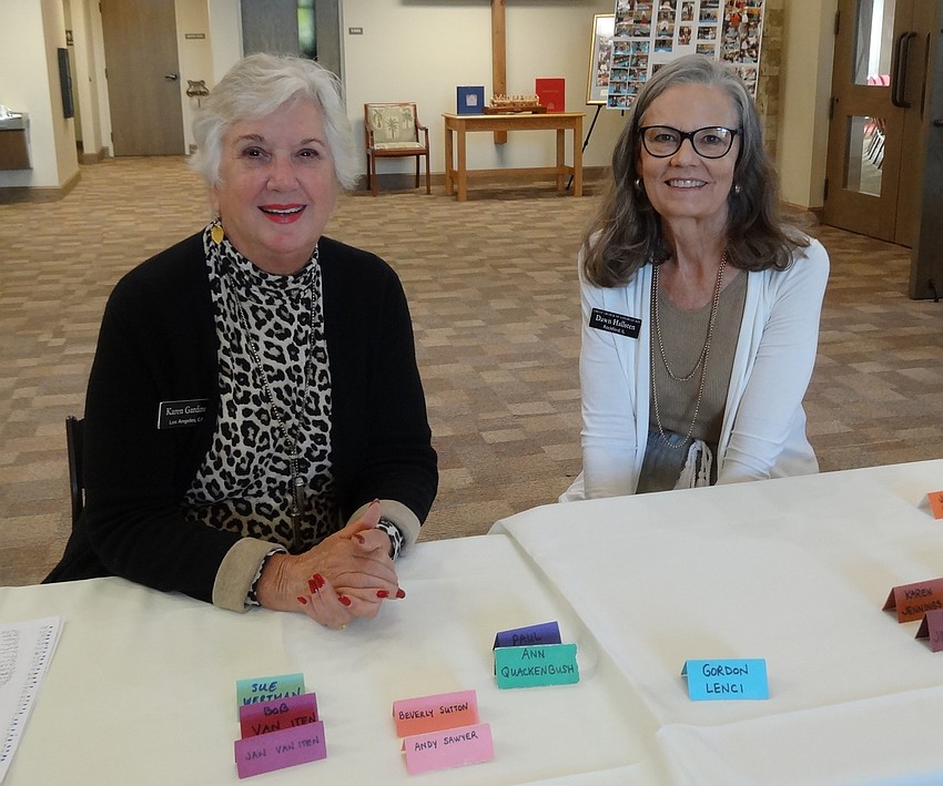 Karen Gardiner and Dawn Hallsten welcome people at the check in desk.