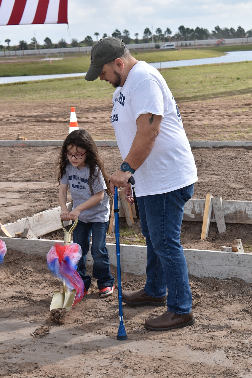 Five-year-old Lucious Gaytan receives a few groundbreaking instructions from her dad Army Sgt. Lucio Gaytan during a ceremony at Sapphire Point to celebrate a no-mortgage home being presented to the Gaytan family.