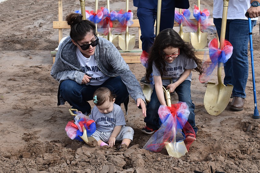 Ivette Gaytan helps her children, 1-year-old Lyanna and 5-year-old Lucious, break ground at their new home site in Sapphire Point in Lakewood Ranch.
