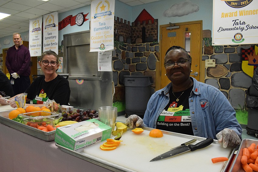 Elvira Ramadani, the kitchen manager, and Laura Rowe, a cook, help the students by cutting fruits and vegetables for students so they can make their creations come to life.