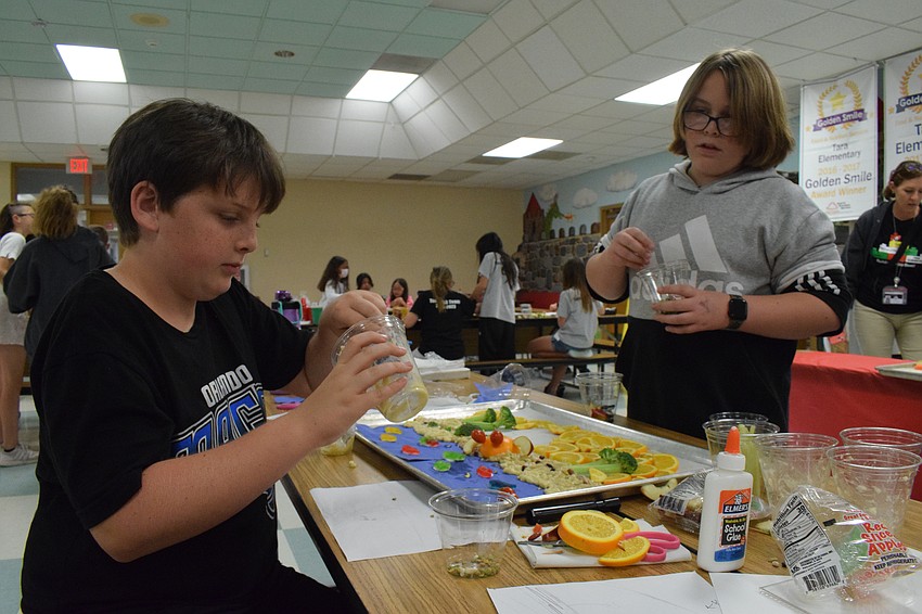 Fifth graders Micah French and R.J. Griffis add to their Florida sunset scenery with crushed banana as sand.