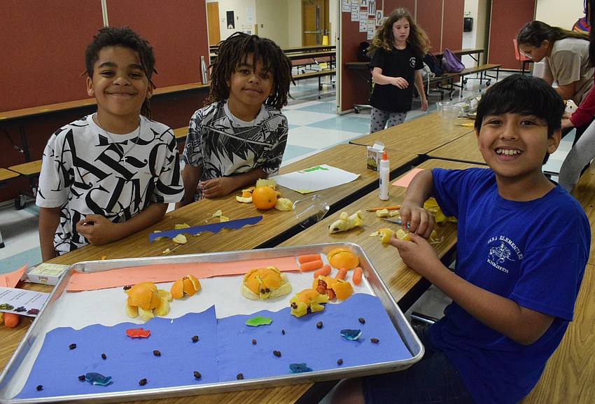 Fifth graders Evans Levasseur, Luke Levasseur and Eli Lopez show off their sea turtles. They added fish, which are the raisins, and sharks, which are the gummies, to complete their display.
