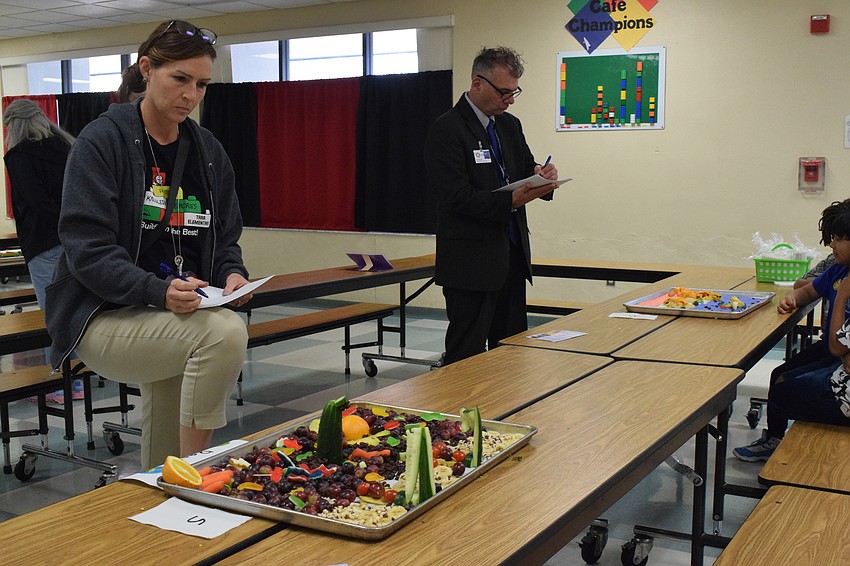 Laura Campbell, the principal at Tara Elementary School, and Doug Wagner, the deputy superintendent of operations for the School District of Manatee County, take a close look at each team's work while judging.