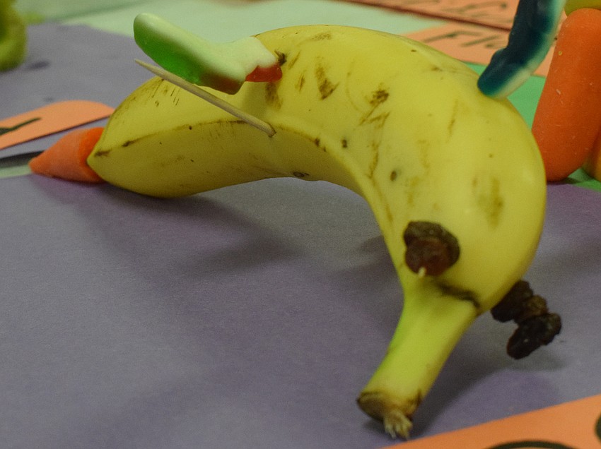 A dolphin swims into the exhibit, made from a banana, raisins, a carrot and gummies.