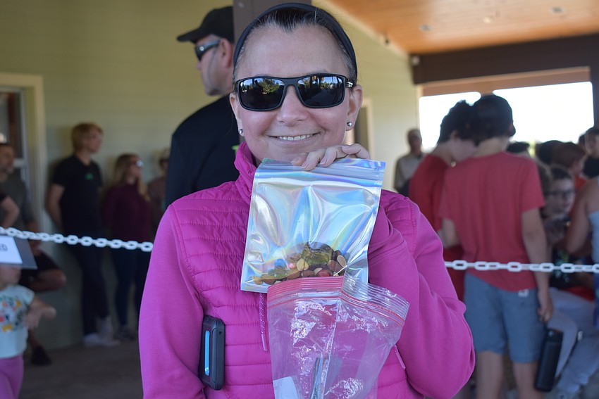 Farrah Fishman hands out mixed nuts to the students and their families.