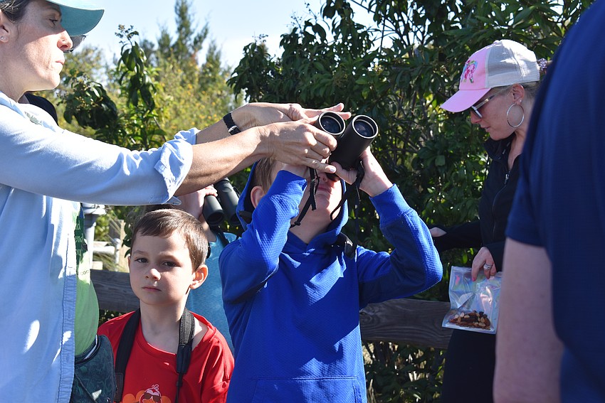 Zachary Friedman looks through binoculars to admire the birds and trees.