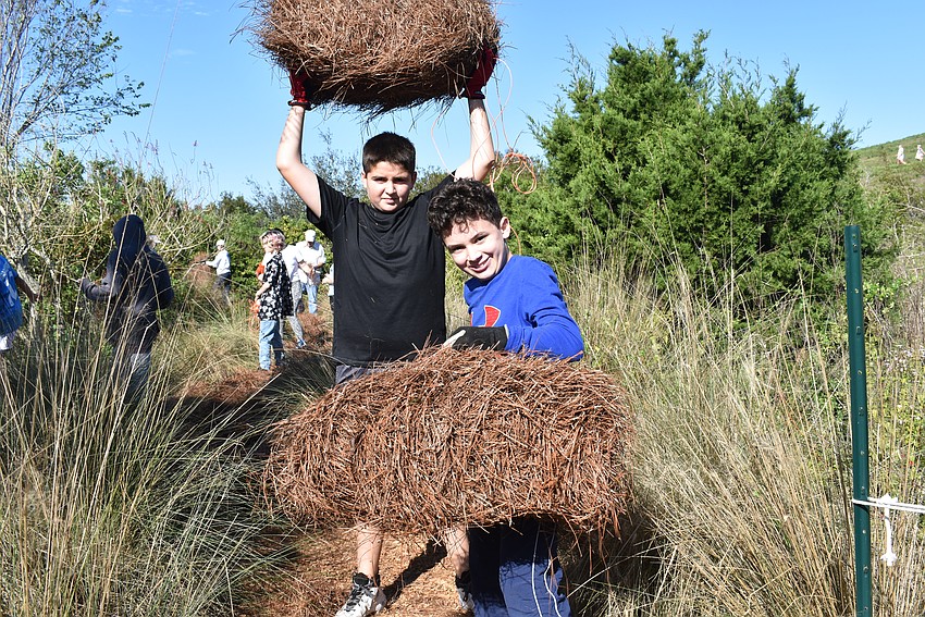 Josh Laporta and Logan Sehwartz showoff their hay before they lay it on the trail.