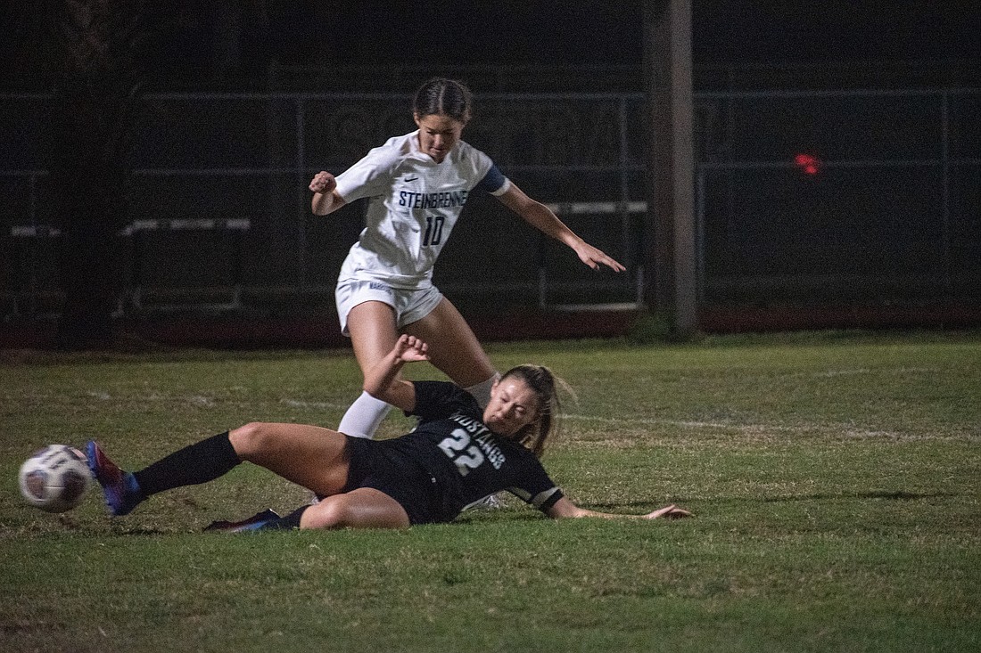 Lakewood Ranch's Regan Kelly (22) slide tackles the ball away from Steinbrenner's Aaliyah  Pitts.