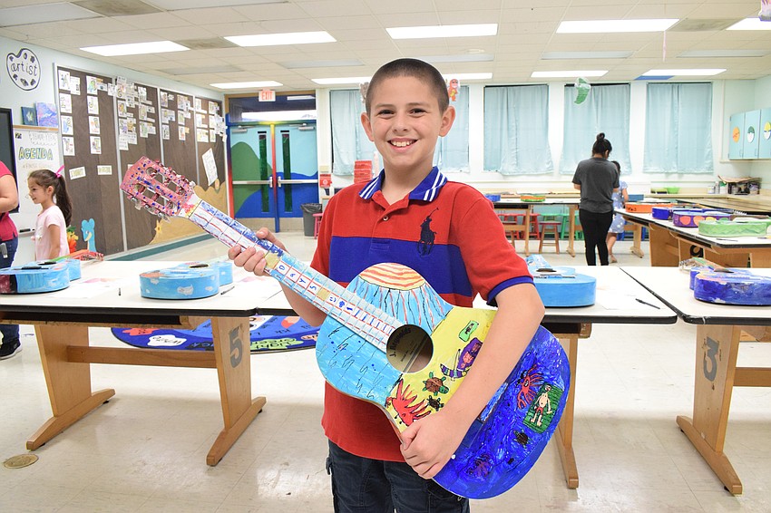Fifth grader Samuel Moya has his guitar, which was painted with a Florida theme, on display during the sweetheart dance.