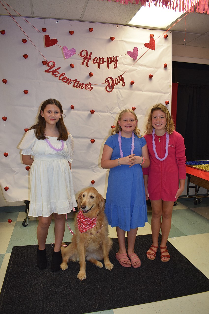 Fifth graders Ava Mohamed, Piper Bush and Liana Sienkiewicz get their photo taken with Callie, the school's therapy dog.