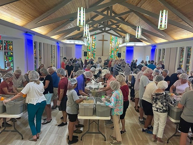 The church's dining hall is filled with 125 community volunteers for a Kids Against Hunger packaging event.