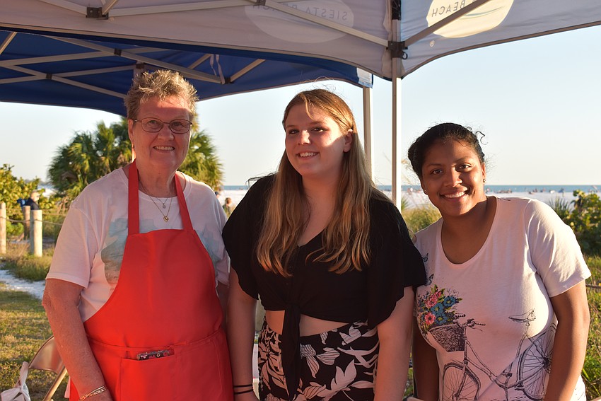 Say 'I Do' volunteers Linda Collins, Haylee Boyer and Tatyana Duarte hand couples their vows.