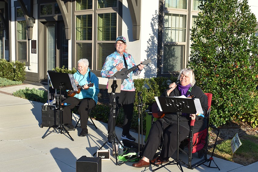 Sue Brady of River Strand, Bibiana Cloonan of Indigo, and Alice Baumann of Harmony of the Aloha Ukulele Club entertain runners at the start of the Run for the Beads at Waterside Place.