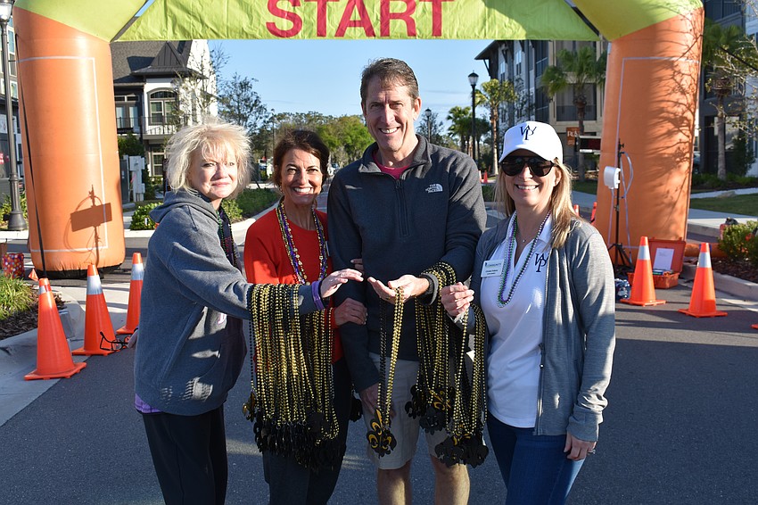 Lakewood Ranch Community Fund Board Members Nancy Sykes, Nicole Ryskamp, Morgan Bentley and Christa Folkers met the runners at the finish line with beads.
