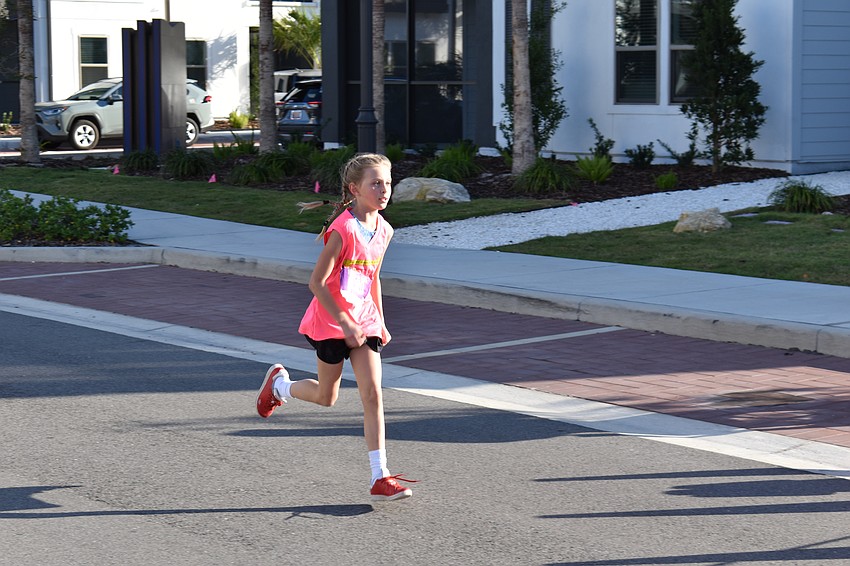 Sarasota's Piper Gruters, 9, finishes strong in the Lakewood Ranch Community Fund's Run for the Beads at Waterside Place.