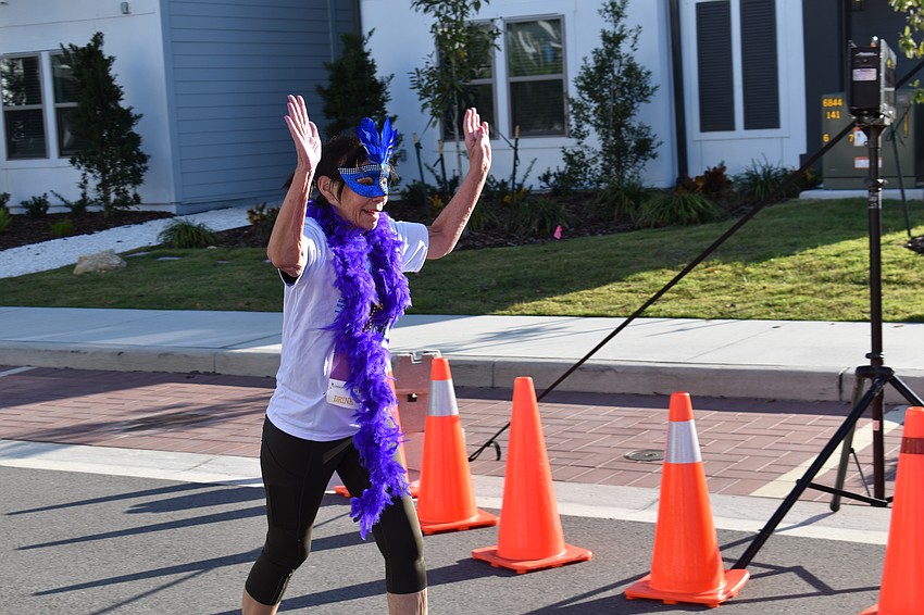 Sarasota's Anna DeFerrari celebrates at the finish line of the Run for the Beads.