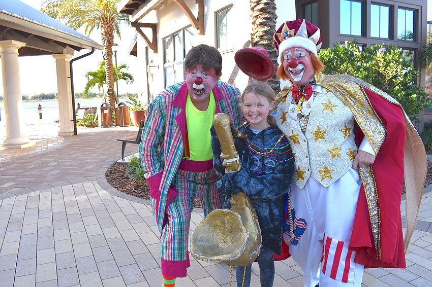 J.P Theron and Chuck Sidlow of the World of Chucko bring a smile to the face of Brookelyn Albee of Lakewood Ranch after the Run for the Beads.