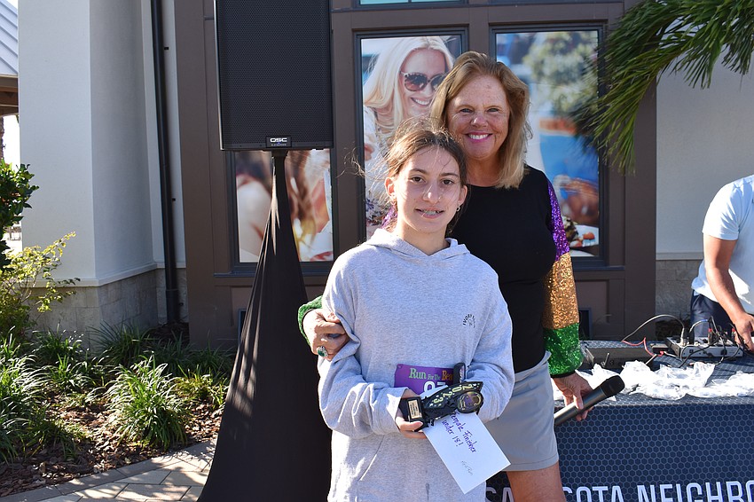 Lakewood Ranch's Rosemary Selke gets the overall girls medal from event chair Annemarie Neubecker.