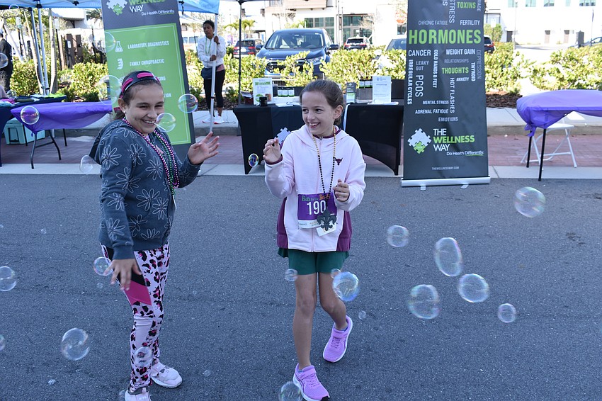 Daniela Soto, 8, of Bradenton and Kayleigh Rhine, 8, of Lakewood Ranch pop as many bubbles as they can during the after-party.