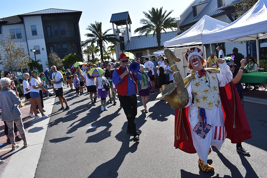 Clown Chuck Sidlow leads the Run for the Beads parade during the after-party at Waterside Place.
