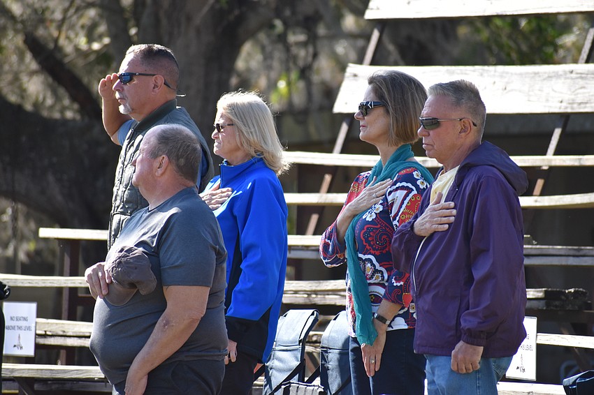 The crowd stands for the national anthem.