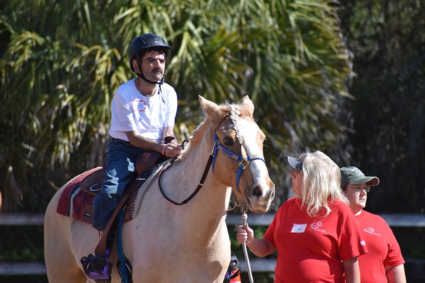 Bradenton's 46-year-old Chris Lombardo rides alongside volunteers Lori Arledge and Erin Greenhalgh
