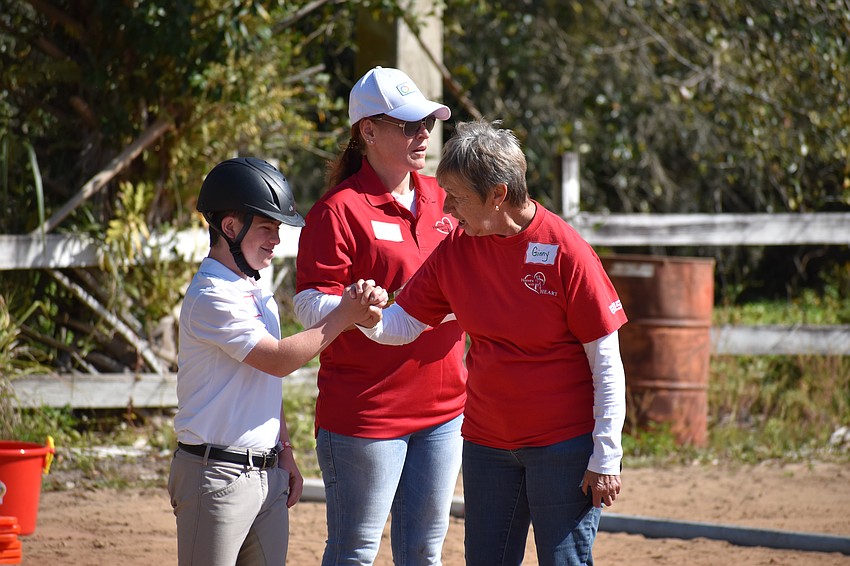 Lakewood Ranch's 13-year-old Mason Kramer prepares for his turn in the arena, with Hooves with Heart volunteers Melissa Newton and Ginny Pellizzaro.